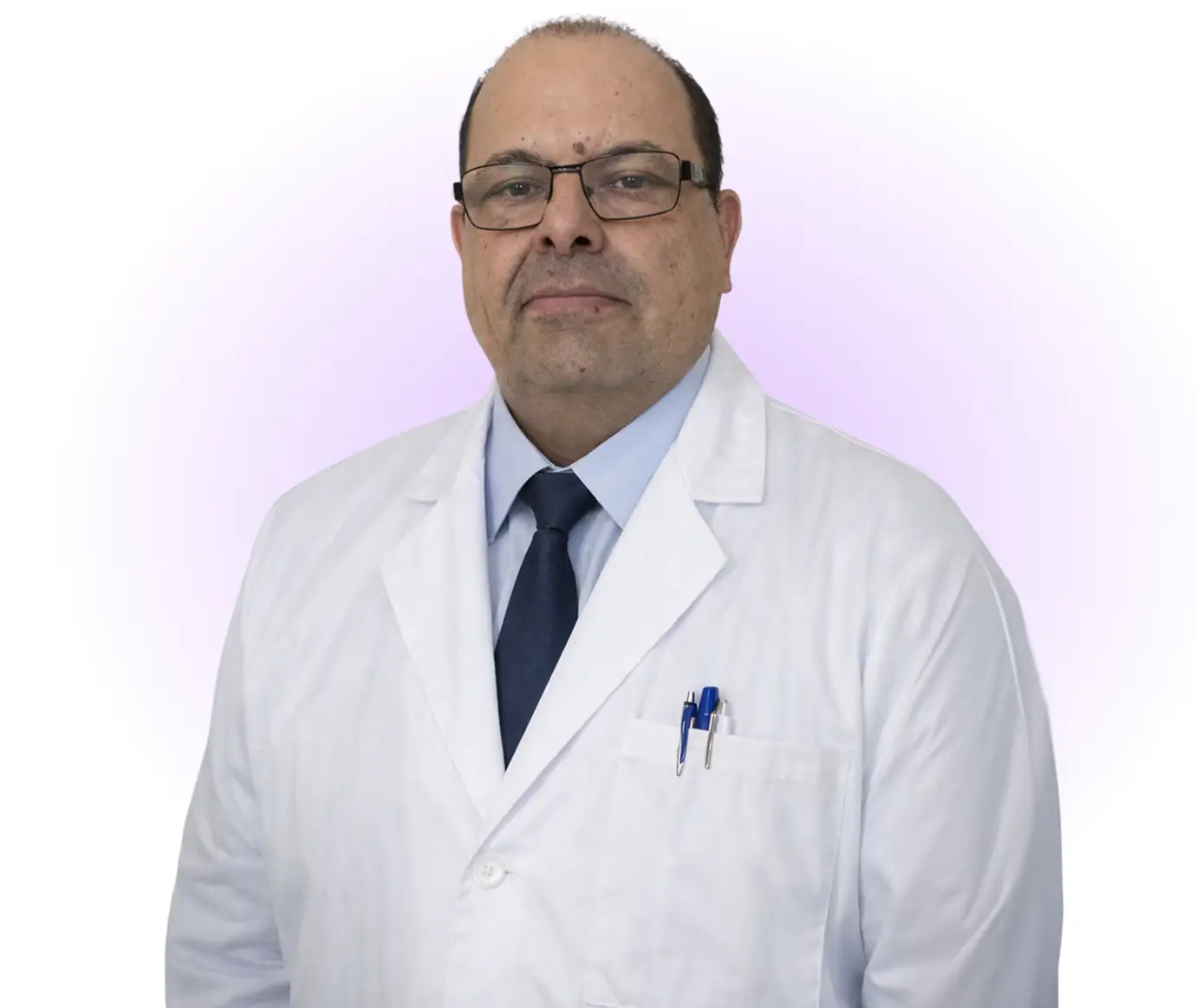 A man wearing a white lab coat and a tie, standing confidently in a professional setting.