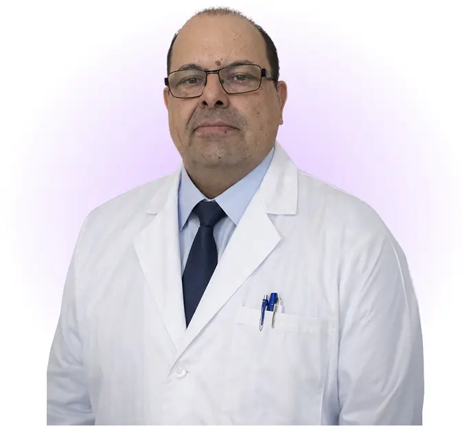 A man wearing a white lab coat and a tie, standing confidently in a professional setting.